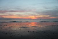 Zonsondergang met weerspiegeling op strand Vlissingen