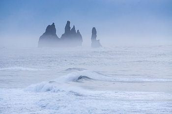 Rotsformatie voor de IJslandse kust in de ochtendmist