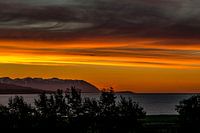 Orange evening sky in a fjord in Northern Iceland looking to the ocean
