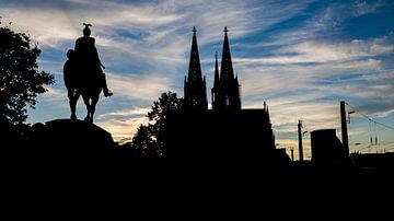 Zwart silhouet van de Dom van Keulen en het ruiterstandbeeld van Jan Schneckenhaus