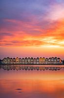 Huisjes in Houten met zonsondergang en reflectie