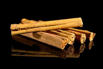 Cinnamon sticks isolated on a black background with reflection