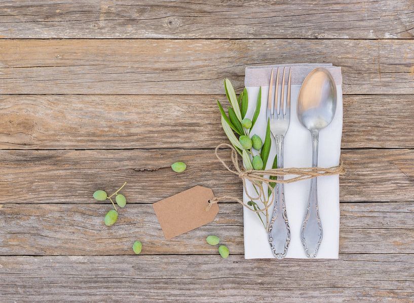 Rustic dinner menu table place setting with napkin, silver cutlery, olives twig by Alex Winter
