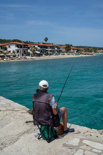 Man vist verticaal op de pier aan de Middellandse Zee