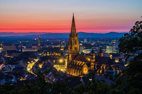 Germany, Red sunset sky and illuminated skyline of freiburg im breisgau panorama
