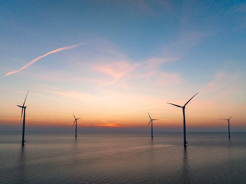 Windturbines in een offshore windpark tijdens zonsondergang