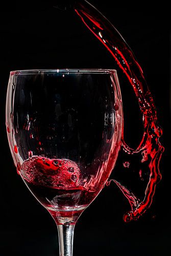 Red wine splashed in and next to the glass