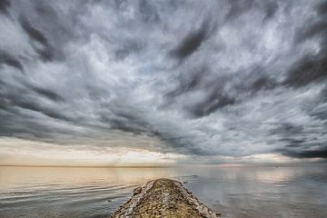 Wolkenlucht boven een spiegelend wateroppervlak vanhet IJsselmeer