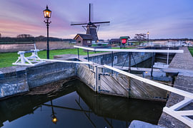 Windmill and lock in the evening light by Sander Poppe