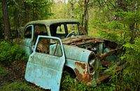 Wreck of old blue car at a junkyard 