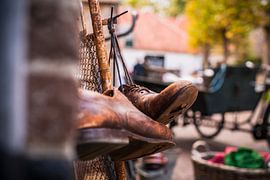 Worn old leather shoes hung on shoelace by Fotografiecor .nl