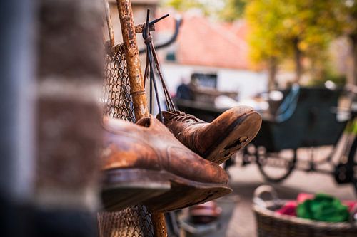 Versleten ouden leren schoenen opgehangen aan schoenveter