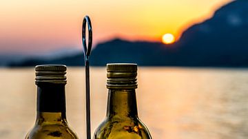 Zonsondergang in Italië met olijfolie en azijn setje aan het Gardameer. van John Duurkoop