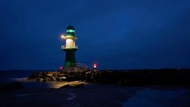 The lighthouse pier light at the west pier on the coast of the city of Warnemünde at night by Heiko Kueverling