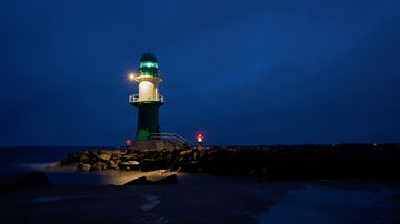 Het licht van de vuurtorenpier op de westpier aan de kust van de stad Warnemünde bij nacht van Heiko Kueverling