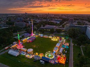 Jahrmarkt bei Sonnenuntergang mit beleuchteten Schaustellern