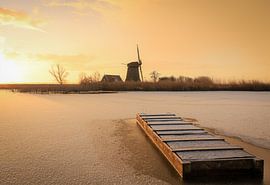 Molen tijdens zonsopkomst in winterse sfeer van Eefje John