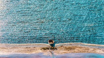 Lonely rowing boat on the beach with turquoise blue sea by Dieter Walther
