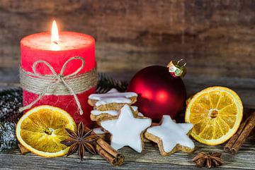 Feestelijke Kerstmis achtergronddecoratie met kaars, koekjes, sinaasappelschijfjes van Alex Winter