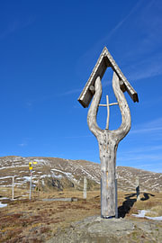 Calvaire en bois dans les montagnes, sous un ciel bleu sur Tomherkules