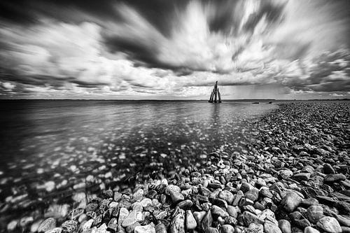 Pebble beach with storm clouds above lake