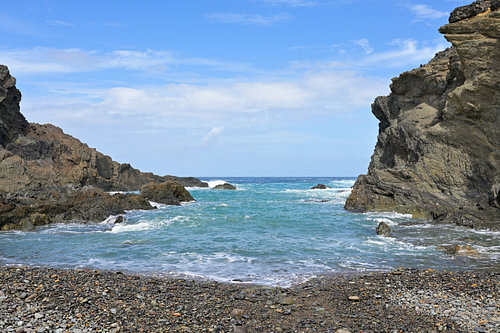 Une crique tranquille à Fuerteventura, nichée entre des falaises escarpées et le bleu de l'Atlantique