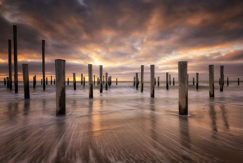 Sonnenuntergang am Strand bei Petten. Schöne Wolken ziehen mit dem kalten Nordwind vorbei, während d