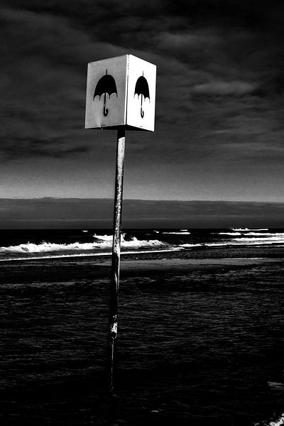 Afbeelding van een bord met paraplu op het strand bij Petten van Wim Stolwerk