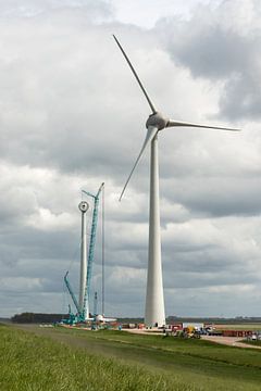 Bouw van een moderne windmolen aan de dijk in Nederland