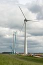 Bouw van een moderne windmolen aan de dijk in Nederland van Tonko Oosterink thumbnail