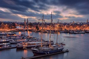 Skyline van Amsterdam met boten op de voorgrond van Dennisart Fotografie