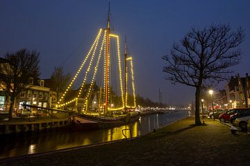 Versierde traditionele zeilboot in Harlingen Nederland in de kersttijd bij nacht van Eye on You