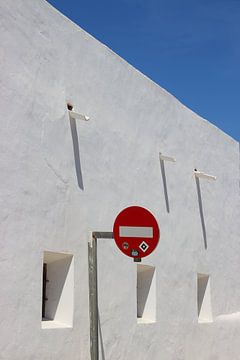 Traffic sign against white wall, window, shade by Daniël Loman