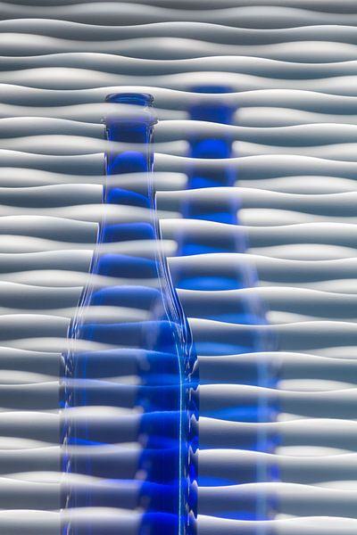 Blauwe glazen fles met achtergrond van golven van Lisette Rijkers