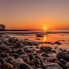 Coucher de soleil sur une plage de galets en Normandie sur Axel Weidner