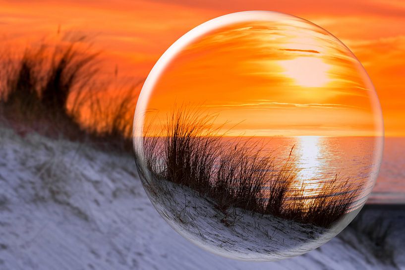 Glaskugel mit orange Sonnenuntergang am Ufer mit Meer Dünen und Strand von Ben Schonewille