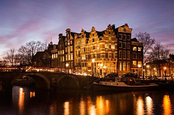 Amsterdams stadszicht met grachtenpanden in de avond