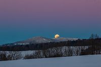 Lunar eclipse in the morning light above the snow