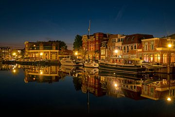 Stadsgezicht van historisch Sneek aan de haven in Friesland bij avond van Eye on You