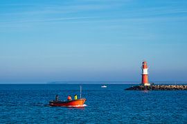 Pier on the coast of the Baltic Sea with fishing boat in Warnemünde by Rico Ködder