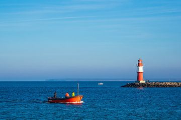 Pier on the coast of the Baltic Sea with fishing boat in Warnemünde by Rico Ködder