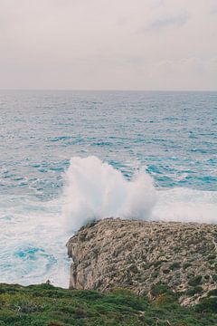 L'eau de mer se heurte à une falaise par une sombre journée d'hiver