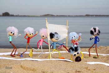 Fubby poppetjes die beach volleybal spelen op het strand.