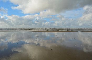 Weerspiegeling van wolken in water van de Noordzee