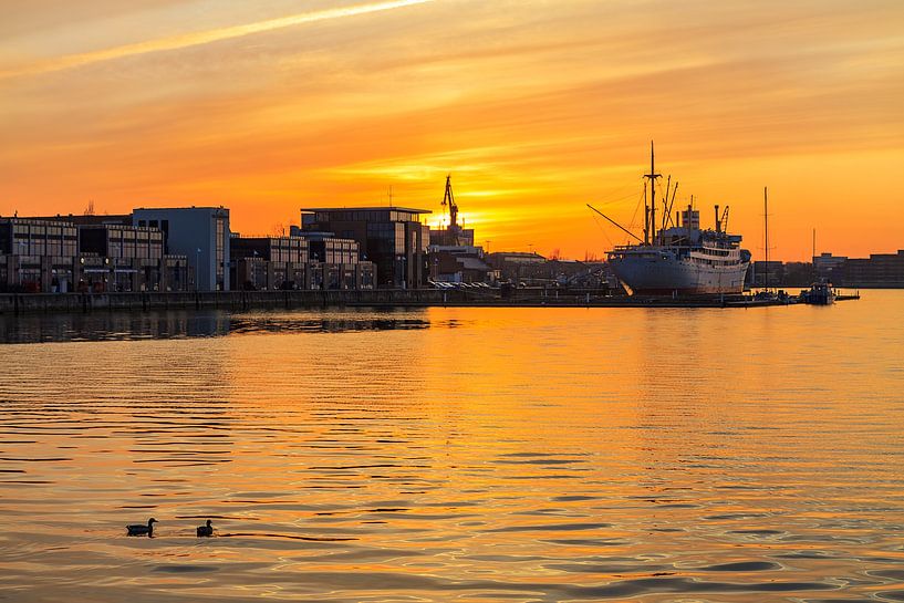 Sonnenuntergang im Stadthafen von Rostock van Rico Ködder