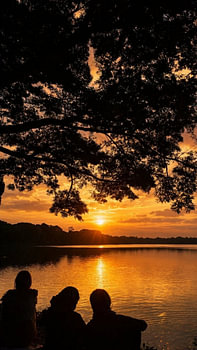 Silhouetten bei Sonnenuntergang über dem See