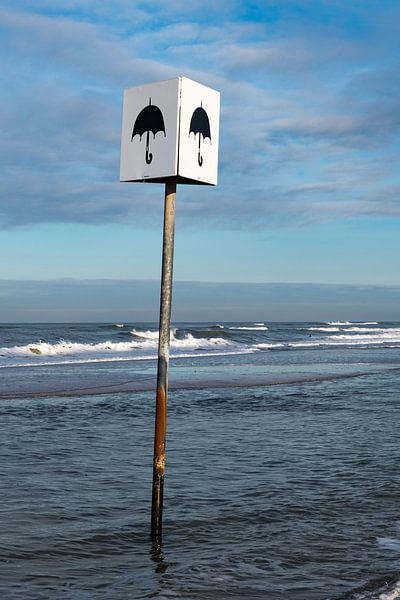 Schild mit dem Bild eines Sonnenschirms am Strand von Petten von Wim Stolwerk