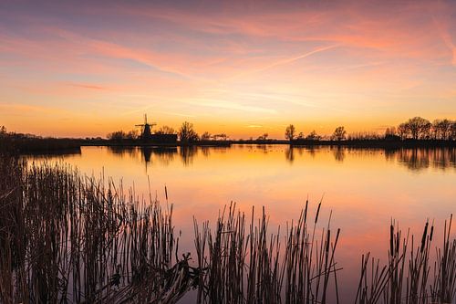 Coucher de soleil apaisant avec un moulin au bord du Schagerwiel
