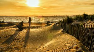Frau in den Dünen am Strand von Grau du Roi Frankreich bei Sonnenuntergang