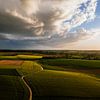 Thunderclouds over green fields by Luc van der Krabben